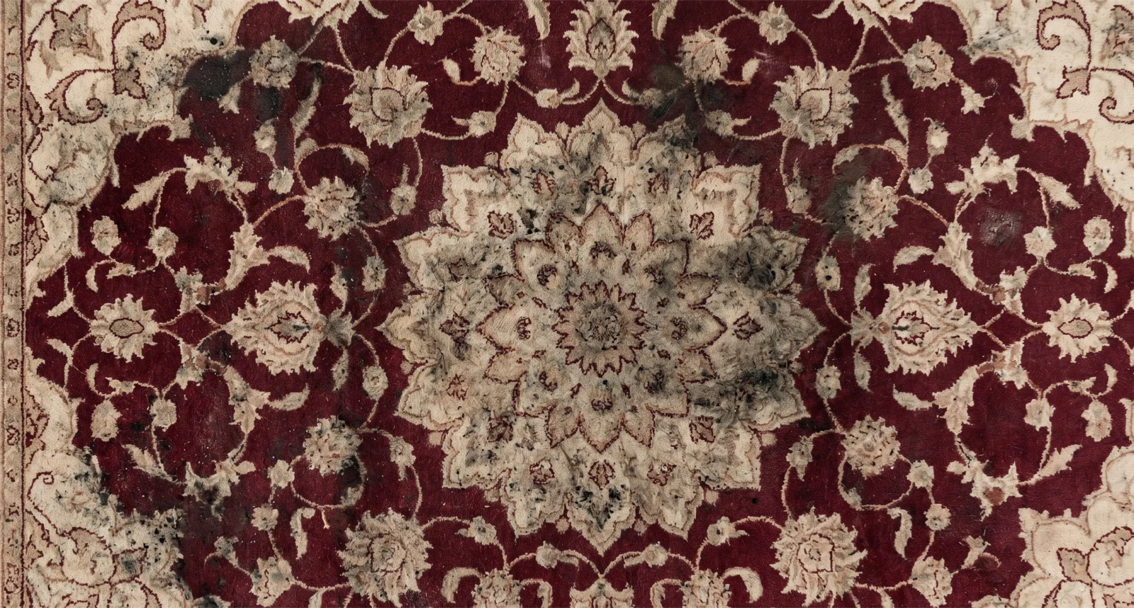 Stained and soiled oriental area rug before professional cleaning